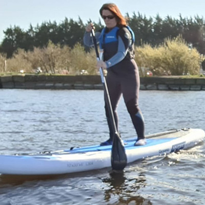 Darcey standing on a paddle board in the water. 