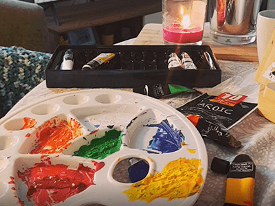 A table with painting supplies during an Art class. 