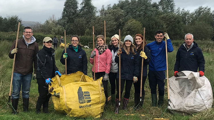 Allstate NI employees volunteers clearing a field.  