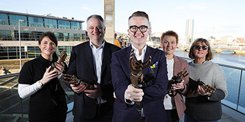 Allstate NI employees holding robotic hands. 