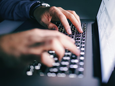 Hands typing on a keyboard. 