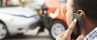 A man talking on a phone about a car accident. 